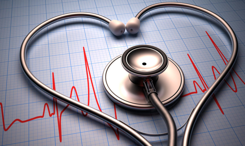 Stethoscope in shape of heart on a graph of the patient's heartbeat.